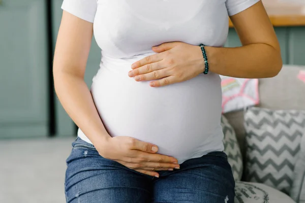 Een Zwangere Vrouw Jeans Een Wit Shirt Houdt Haar Handen — Stockfoto