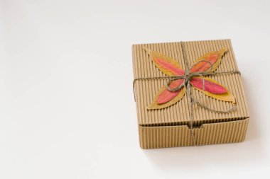 zanaat hediye kutusu, bir yay ve sonbahar bej arka plan üzerinde yaprakları düştü ile dize ile bağlı. Kopyalama alanı