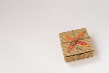 zanaat hediye kutusu, bir yay ve sonbahar bej arka plan üzerinde yaprakları düştü ile dize ile bağlı. Doğum günü veya şirket hediyesi için bir hediye