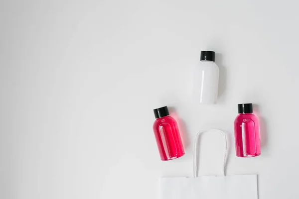 Kosmetikflaschen Aus Geschenk Oder Geschenkpapiertasche Auf Weißem Hintergrund Eine Reihe — Stockfoto