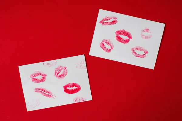 Women\'s lips lipstick kiss print set for Valentine\'s Day and love collection on white paper on red . The shape of the lip makeup gloss sample smear.