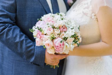 Gelin ve damadın elinde gelinin narin buketi, yakın çekim