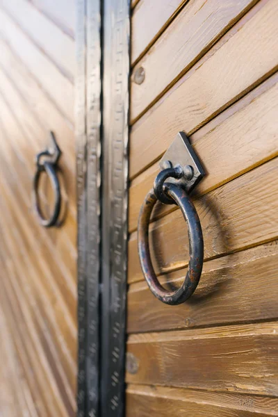 Metal round door handles on wooden door leaf