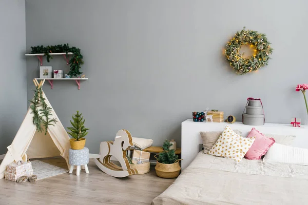 クリスマスや新年のために飾られた寝室や子供部屋のインテリア ベッド ウィグワム 子供のスイング馬 壁にクリスマスの花輪 — ストック写真