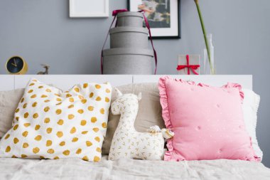 Parlak neşeli yastıklar, tek boynuzlu at yastığı Noel için süslenmiş yatağın üstünde.