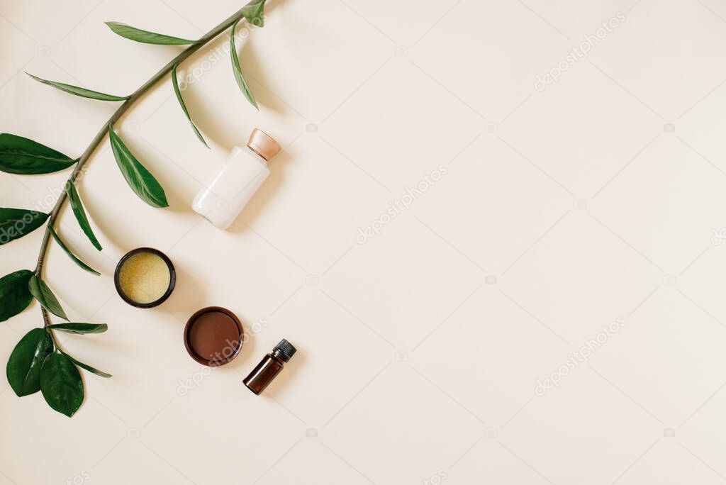 Skin care products, natural cosmetics. Flat lying image on a light beige background. Cosmetic bottles for skin care, serum, oil and organic green leaf. The concept of home and beauty product.