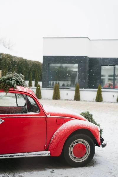 Czerwony Samochód Choinką Stoi Ulicy Pobliżu Domu Pada Śnieg — Zdjęcie stockowe