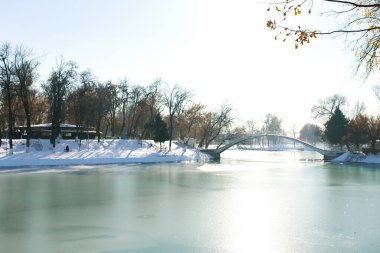 Taşkent, Özbekistan. Şubat 2019. Kış mevsiminde Özbekistan Ulusal Parkı 'nda bulunan Reservoir (Komsomol Gölü), buzla kaplı ve göl üzerinde bir köprü bulunuyor.