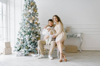 Noel aile portresi evinizde şenlikli bir oturma odası, ebeveynler ve çocuk.