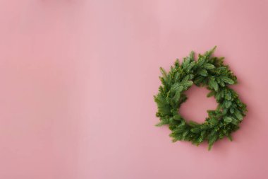 Noel çelengi, köknar dalları üzerinde parlak pembe bir arkaplan ve fotokopi alanı.