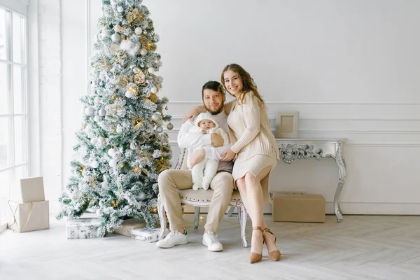 Noel aile portresi evinizde şenlikli bir oturma odası, ebeveynler ve çocuk.