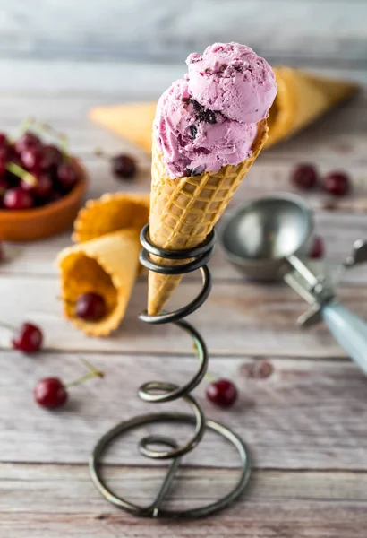 Uma vista de perto de um cone de sorvete de cereja pronto para comer . — Fotografia de Stock