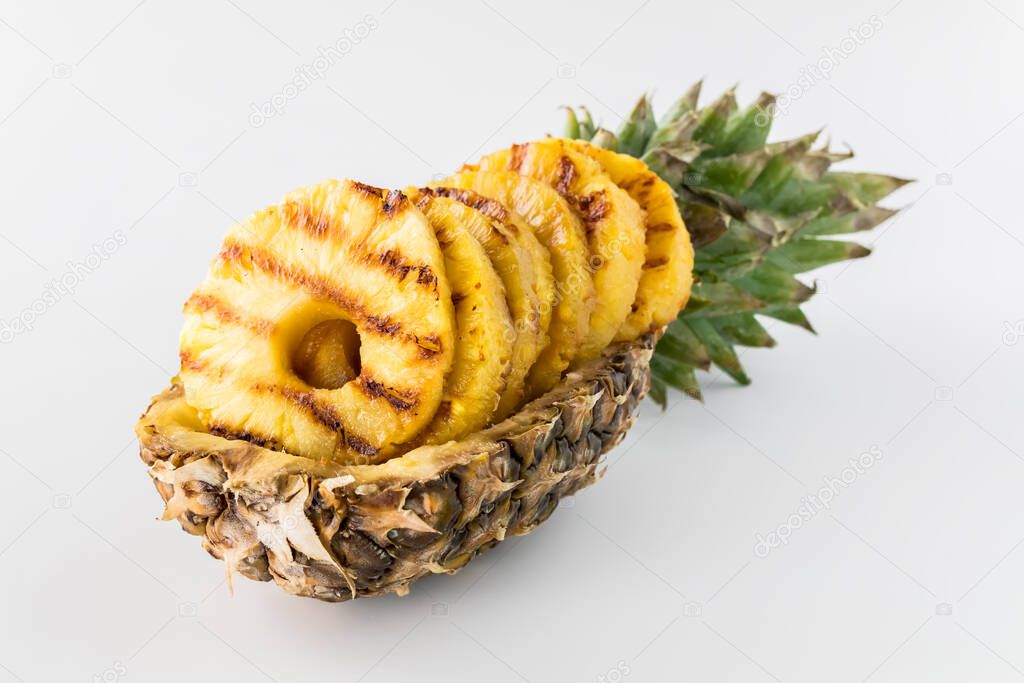 Pineapple boat filled with grilled pineapple rings.