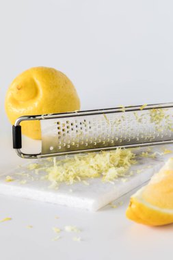 Close up of lemon zest on a marble slab surrounded by lemons with copy space above and below. clipart