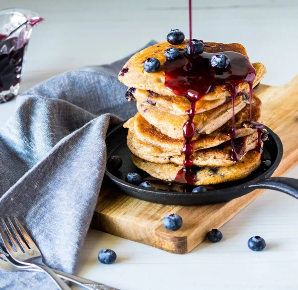 Stack of blueberry pancakes with blueberry syrup being poured on top. — Stock Photo, Image