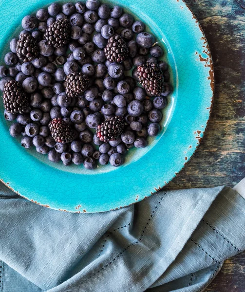 Яскраво-блакитна тарілка з чорниці та ожини, готова до їжі . — стокове фото
