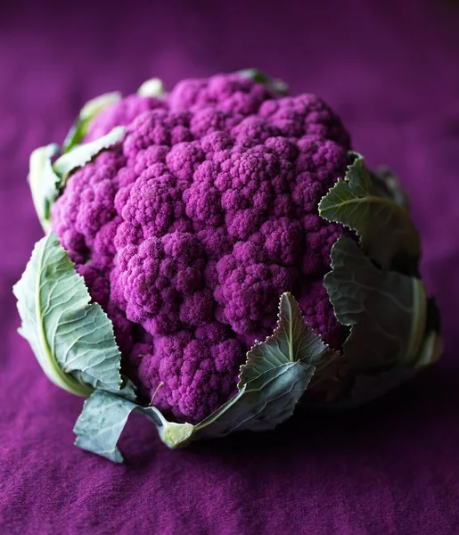 Close up of purple cauliflower against a purple background in soft focus. — Stock Photo, Image