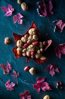 Akçaağaç yaprağı şeklindeki cam tabağın yukarıdan görünüşü tamamen kuru akçaağaç yapraklarıyla çevrili.. 