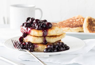 Üzerine sıcak yaban mersini sosu konmuş üç pofuduk krep..