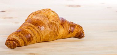 Ahşap bir yüzeyde izole edilmiş bir kruvasan