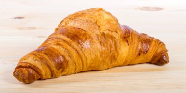 Ahşap bir yüzeyde izole edilmiş bir kruvasan