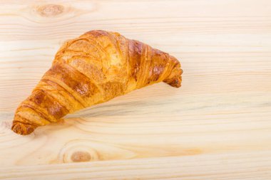 Ahşap bir yüzeyde izole edilmiş bir kruvasan