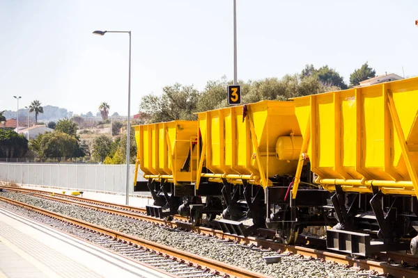Comboio de lastro. Um grande trem amarelo de carga na estação — Fotografia de Stock