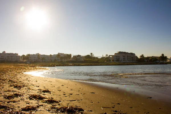 Beach in Denia, Spain, at sunrise with tourist buildings in the background — Stock Photo, Image