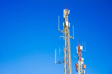 Telecommunication antennas with blue sky in the background on a sunny say clipart
