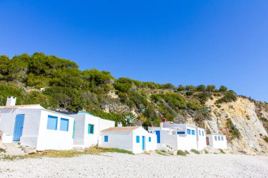 Small white fishermen houses in Barraca Portitxol beach, in Javea, Spain clipart