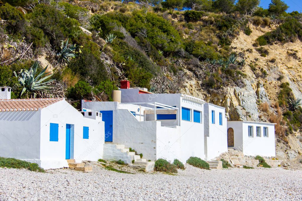 Small white fishermen houses in Barraca Portitxol beach, in Javea, Spain