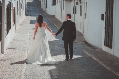Gelin ve damat bir Akdeniz köyde cadde boyunca yürüyüş