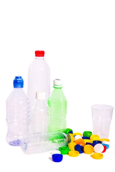 Pollution plastique. Quelques bouteilles et bouchons vides en plastique isolés sur fond blanc — Photo