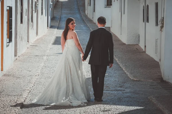 Gelin ve damat bir Akdeniz köyde cadde boyunca yürüyüş