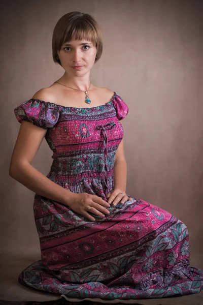 Portrait of a young woman in a vintage dress. Shooted in the studio on a flat background.