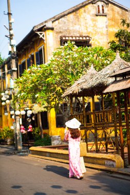 Hoi An, Quang Nam, Vietnam, 26 Nisan 2018: Vietnam kadın ao dai giyiyor. Eski ile cadde görünümü Hoi bir antik kent evleri