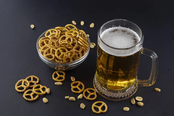 Bright, cold beer in a glass beaker with crackers