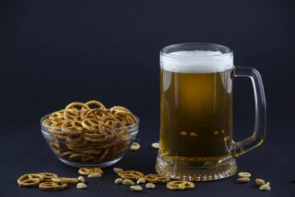 Bright, cold beer in a glass beaker with crackers