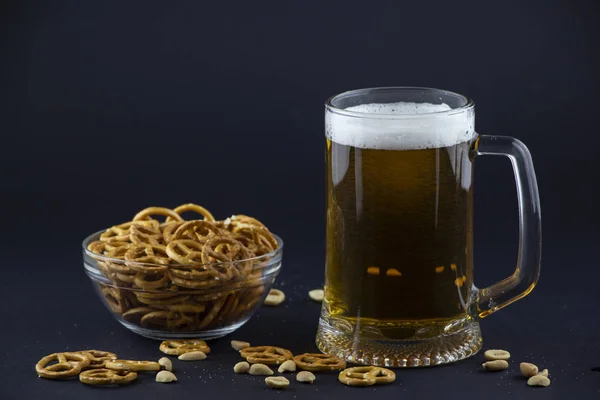 Bright, cold beer in a glass beaker with crackers