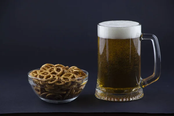 Bright, cold beer in a glass beaker with crackers