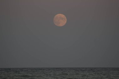 deniz üzerinde kırmızı dolunay