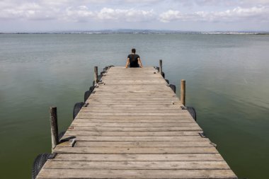 Sabah gökyüzünde göl tarafından bir dock adam