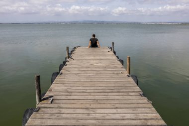 Sabah gökyüzünde göl tarafından bir dock adam