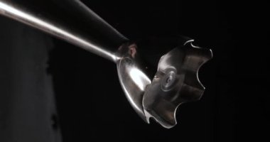 4K içerisinde izole edilmiş koyu siyah arkaplan üzerindeki bir mikserin yakın plan görüntüsü