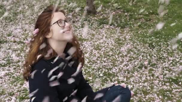 Jeune Fille Rousse Soufflant Des Pétales Roses Sakura Dans Parc — Video