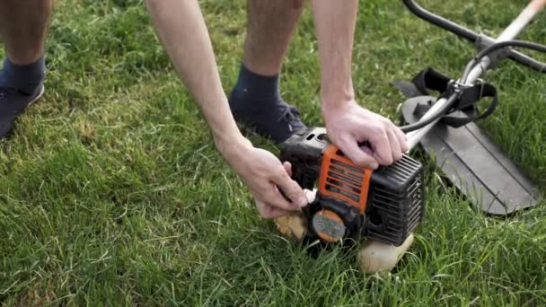 Un homme démarre une tondeuse à essence — Video