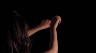 Siyah bir arka planda kaotik bir şekilde hareket eden bir piyanistin kadın ellerine yakın çekim. Foot 3840x2160 (4K) gerçek zamanlı olarak yapay profesyonel ışıklandırmayla çekildi.