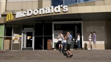 Karantina sırasında McDonald 's Express' te kuyrukta bekleyenler. İnsanlar koruyucu maskeleri olmadan mesafelerini koruyup yürümezler. Yüksek kalite 4k görüntü