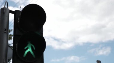 Mavi bulutlu gökyüzünün arka planında yayalar için trafik ışığı. Uluslararası trafik ışığı günü