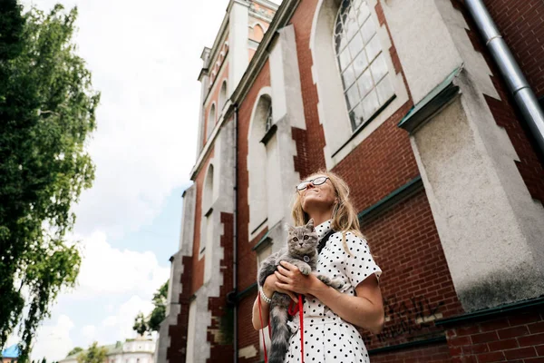 Kız İskoç bir kediyle yürüyor.